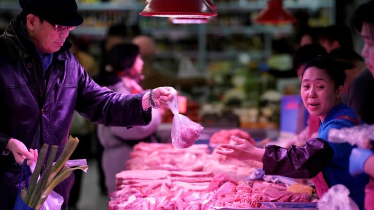 Các nhà cung cấp thịt lợn tại một thị trường Bắc Kinh: Trung Quốc là nhà sản xuất và tiêu thụ thịt lớn nhất thế giới. (Ảnh: Reuters)