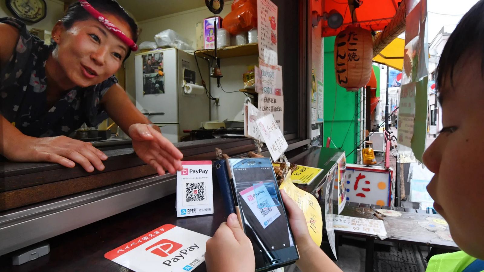 Một người tiêu dùng quét mã QR để thanh toán tại một cửa hàng bánh bao bạch tuộc ở Tokyo: còn quá sớm để nói liệu công chúng Nhật Bản có chuyển sang tiền điện tử hay không.