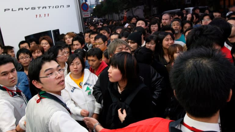 Các trợ lý cửa hàng giữ lại một đám đông ở Tokyo đang kêu gọi mua máy chơi game PlayStation 3, phát hành vào tháng 11 năm 2006.