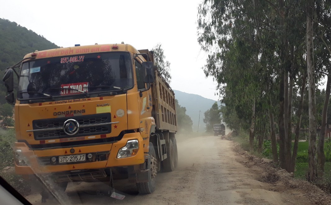 Các xe tải trọng lớn “nối đuôi” nhau ra, vào chở đất, đá cày xới Tỉnh lộ 542E qua xã Hưng Tây, huyện Hưng Nguyên, tỉnh Nghệ An