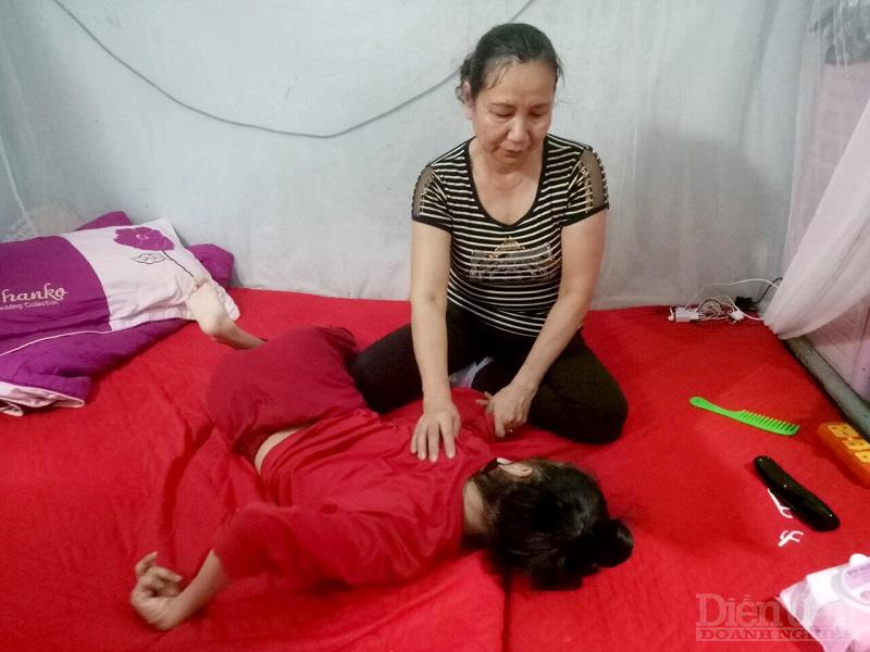 Trong căn phòng trọ chật chội, bà Phạm Thị Hường đang chăm sóc người con bị tật nguyền 21 tuổip/nằm một chỗ