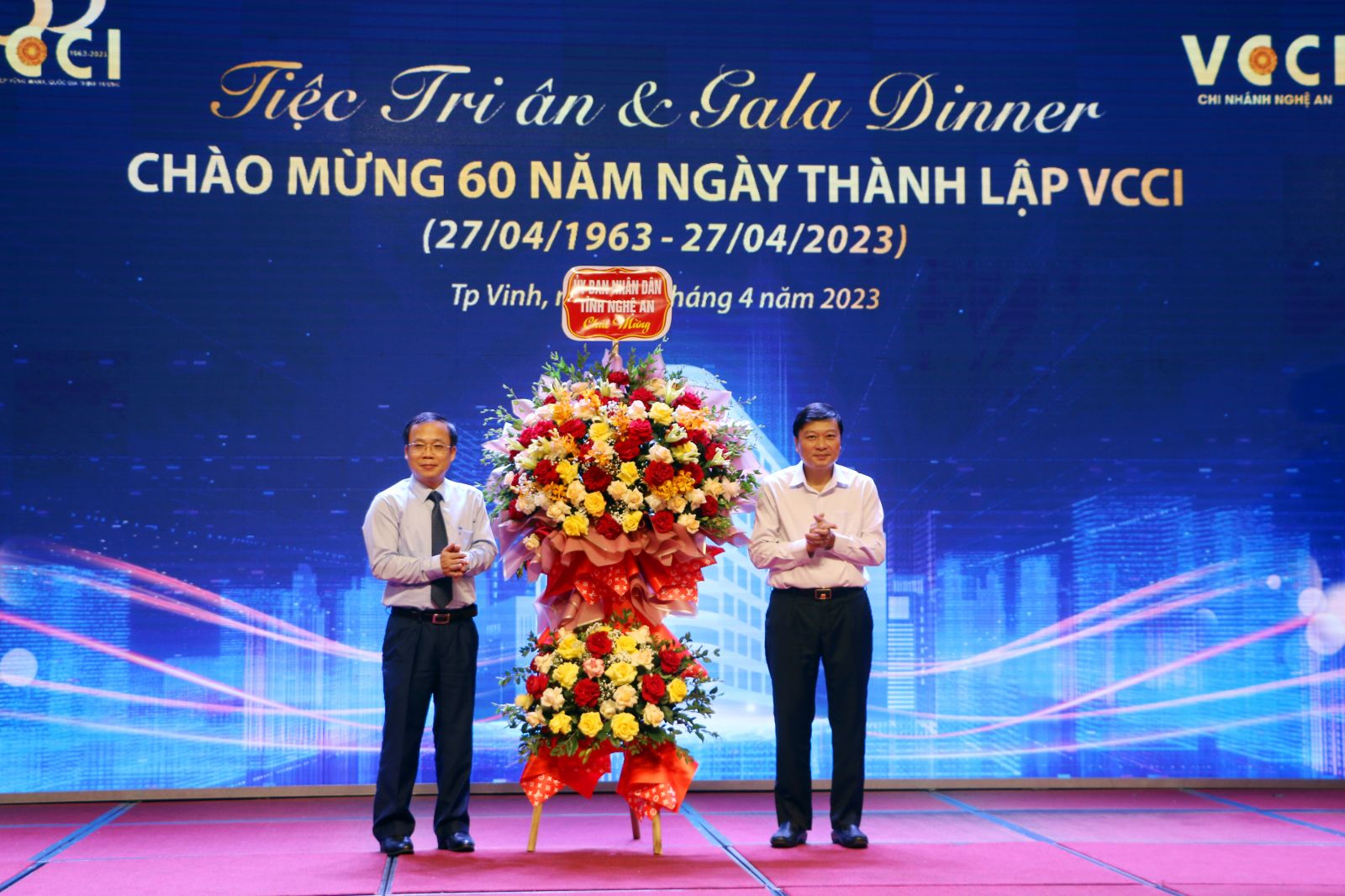 Thay mặt đại diện lãnh đạo UBND tỉnh Nghệ An, ông Lê Hồng Vinh tặng hoa chúc mừng cho đại diện VCCI là ông Bùi Trung Nghĩa - Phó Chủ tịch VCCI nhân dịp 60 năm ngày thành lập VCCI