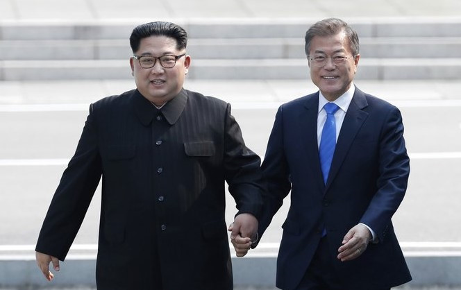 Hai nhà lãnh đạo nắm tay nhau tiến về nhà Hòa Bình (Ảnh Reuters)