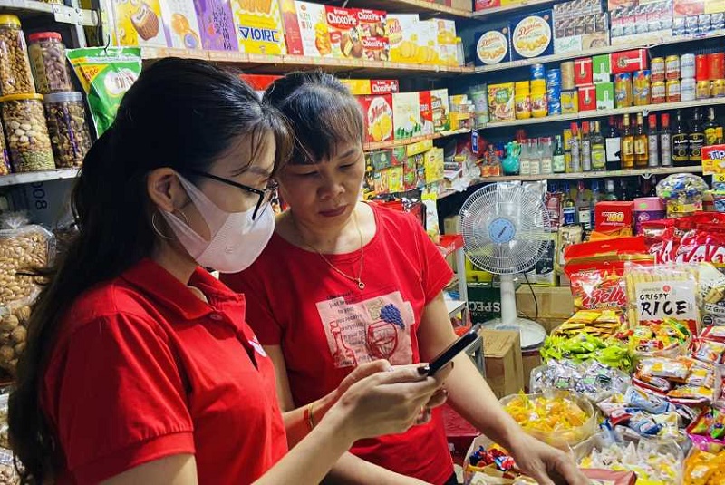 Viettel Quảng Ninh hướng dẫn chủ cửa hàng tạp hóa tại Chợ Hạ Long I cài đặt ứng dụng Viettel Money (Ảnh: Báo Quảng Ninh)