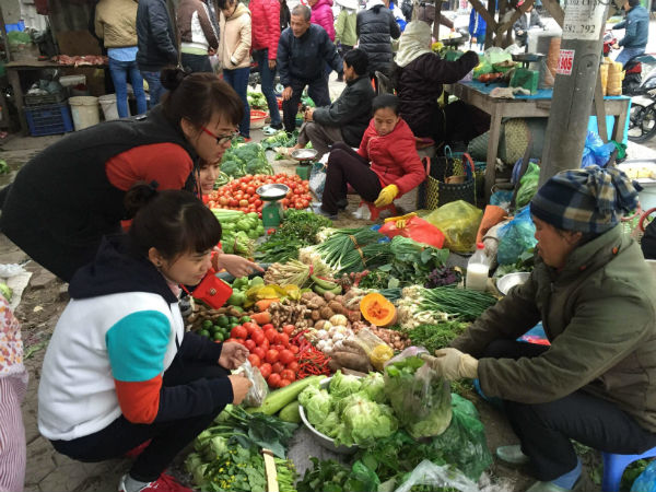 Công nhân mua rau ở khu chợ thuộc thị trấn Trường Sơn, huyện An Lão. Ảnh Minh Hương