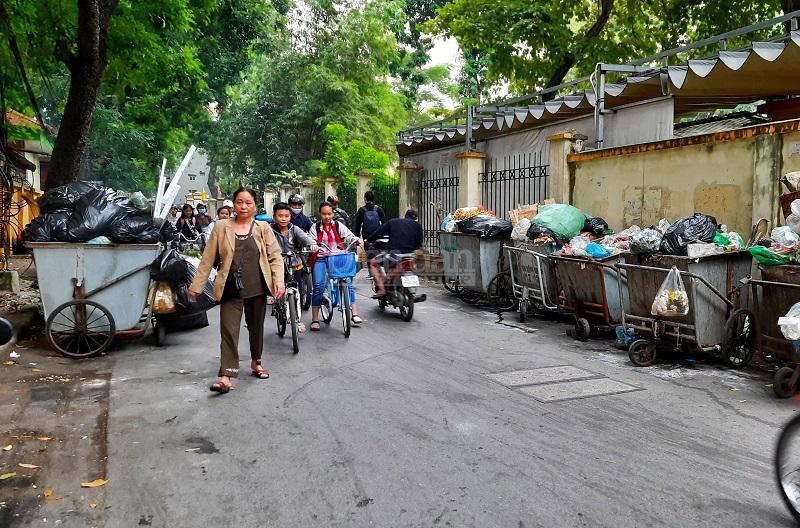 Không loại trừ một đâu, rác ùn ứ cũng được tập kết ngay tại gần một cổng trường học trên đường Hoàng Tích Trí, quận Đống Đa - Ảnh: Gia Nguyễn/DĐDN