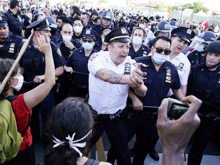 9.	Trong vài ngày qua, những người biểu tình ở nhiều thành phố đã báo cáo các cuộc đụng độ ngày càng dữ dội với cảnh sát. Một sĩ quan cảnh sát NYPD phun ra những người biểu tình khi họ đụng độ trong một cuộc tuần hành ở Brooklyn, New York, ngày 30 tháng Năm. REUTERS / Eduardo Munoz
