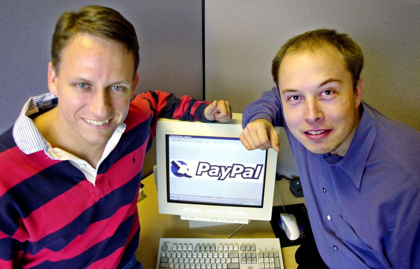 Peter Thiel của PayPal và người sáng lập Elon Musk, bên phải, tạo dáng với logo PayPal tại trụ sở công ty ở Palo Alto, California (Paul Sakuma/AP).