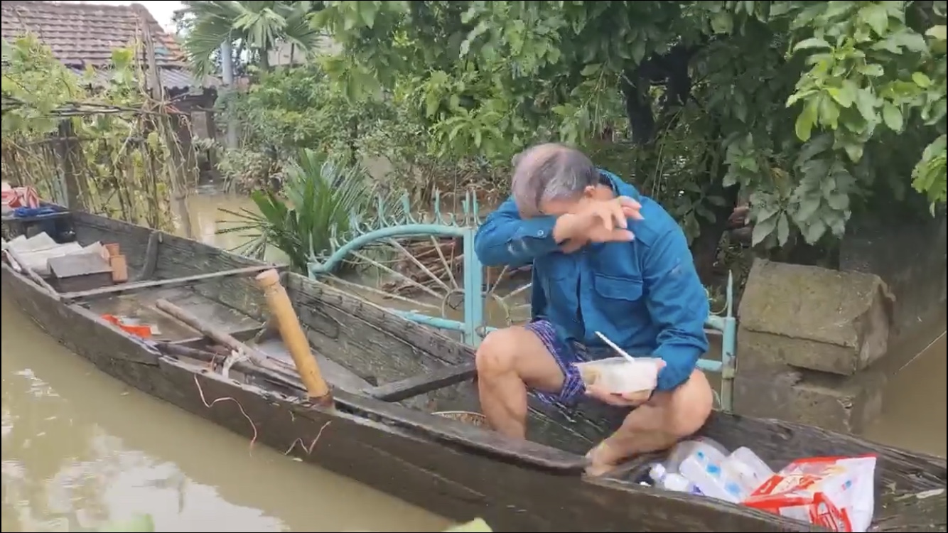 Hình ảnh một cụ ông bật khóc khi nhận được thực phẩm hỗ trợ sau nhiều ngày lênh đên giữa biển nước. (Ảnh được cắt từ video)