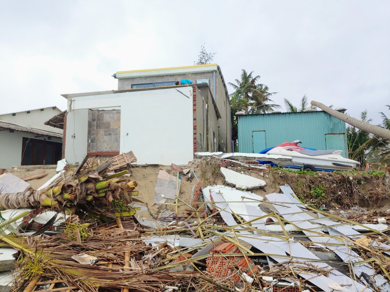 Một người dân đang sửa lại nhà của mình sau những ngày bão, gió và sóng biển hoành hành.