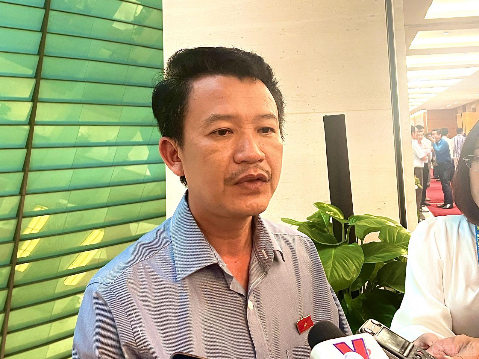  đại biểu Trần Quang Minh, đoàn Quảng Bình trả lời báo chí bên hành lang quốc hội chiều 7/6.